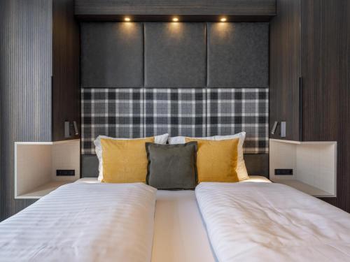 a bedroom with a large bed with yellow pillows at Alpenchalet Lambert in Sankt Lambrecht