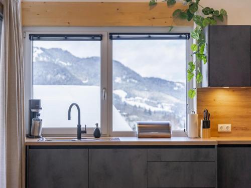 a kitchen with a sink and a large window at Alpenchalet Lambert in Sankt Lambrecht