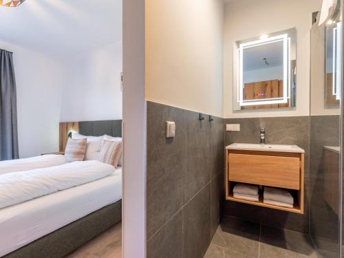 a bedroom with a bed and a sink and a mirror at Grebenzen Lodge 53 in Sankt Lambrecht