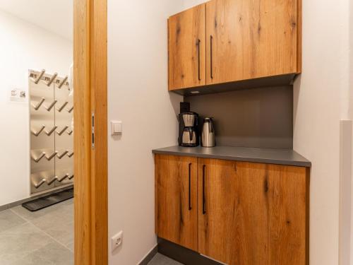 a kitchen with wooden cabinets and a wine cellar at Grebenzen Lodge 53 in Sankt Lambrecht