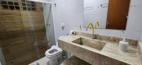 a bathroom with a sink and a toilet at Resort&House,4 Quartos, 8 pessoas, Beach tenis, Bike, Golfe, Pesca, Ar, Wifi fibra, TV a cabo e Lareira in Santa Bárbara do Rio Pardo