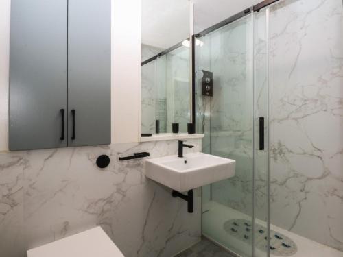 une salle de bain blanche avec lavabo et douche dans l'établissement 1 Oakley Wharf, à Porthmadog
