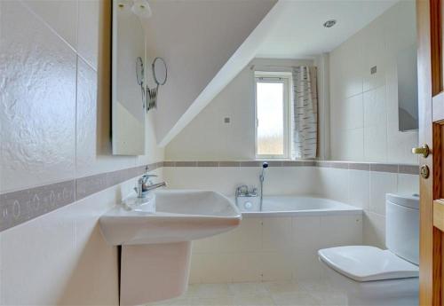 a bathroom with a sink and a tub and a toilet at 5 Bed in Croyde oc-bonac in Croyde