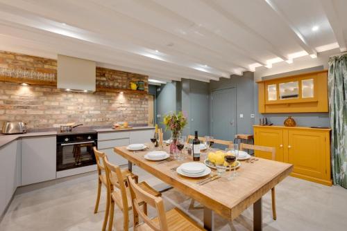 a kitchen with a wooden table and some chairs at The Barn at The Foldyard in Holme upon Spalding Moor