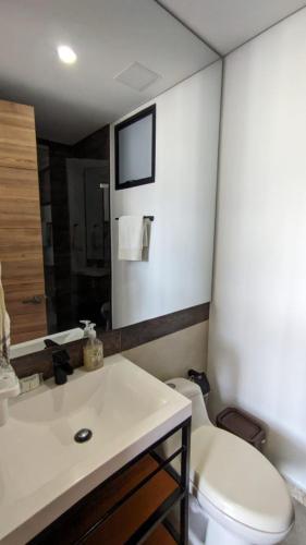a bathroom with a white toilet and a sink at Vita905 RODADERO in Santa Marta