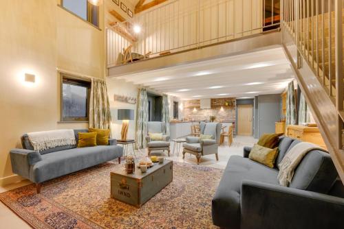 a living room with two couches and a table at The Barn at The Foldyard in Holme upon Spalding Moor