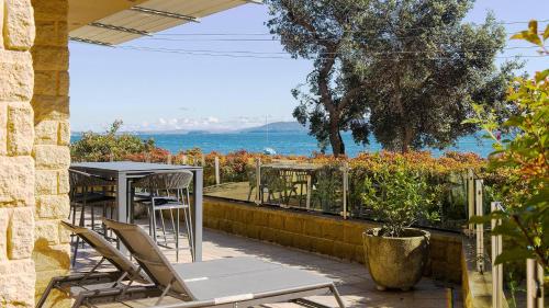 a patio with a table and chairs and the ocean at Mariners One 1 at 39 Victoria Parade in Nelson Bay