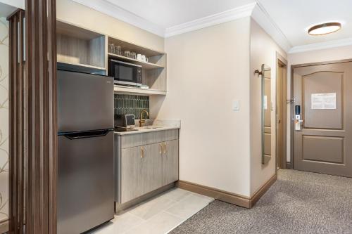 a kitchen with a refrigerator freezer next to a door at Velora Hinton, an Ascend Collection Hotel in Hinton