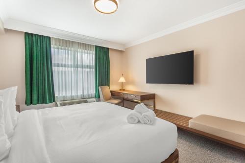 a hotel room with a bed and a flat screen tv at Velora Hinton, an Ascend Collection Hotel in Hinton