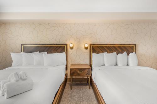 two beds sitting next to each other in a hotel room at Velora Hinton, an Ascend Collection Hotel in Hinton