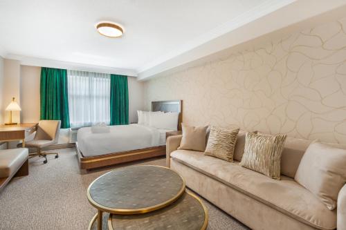 a hotel room with a couch and a bed at Velora Hinton, an Ascend Collection Hotel in Hinton