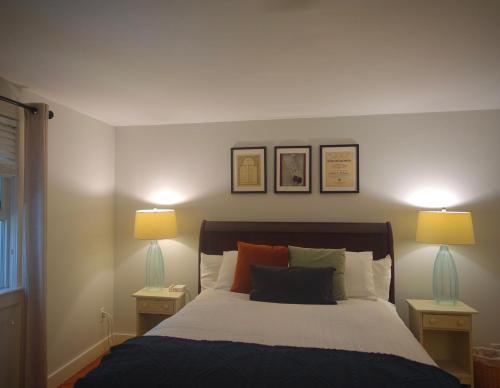 a bedroom with a bed with two lamps on it at Sea Meadow Inn in Brewster