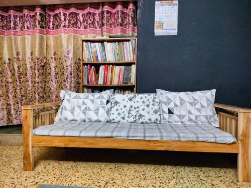 a wooden bench with pillows in a room at Swanky Homestay in Kolhapur