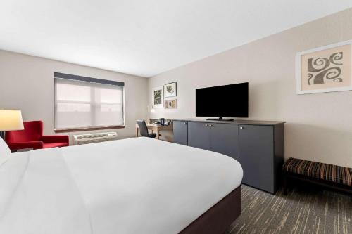 a hotel room with a bed and a flat screen tv at Country Inn & Suites by Radisson, Macon North, GA in Macon