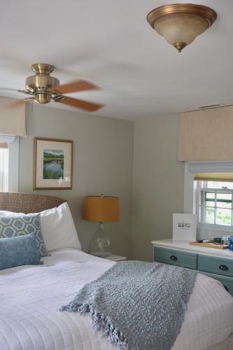 a bedroom with a bed and a ceiling fan at Sea Meadow Inn in Brewster