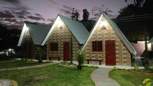 a small house with a pitched roof at night at Chalé Paraíso Guararema 1 in Guararema