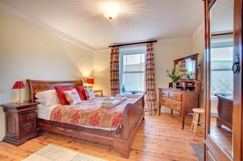 a bedroom with a bed and a dresser and a window at Hillside in Croyde