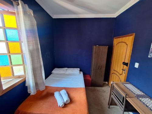 a blue room with a bed and a window at Lindo flat Caxambu Vila Rica Pampulha in Venda Nova