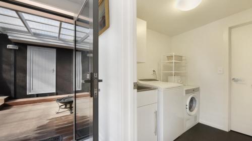 a bathroom with a washing machine and a sink at Koraha - Queen Charlotte Sound Holiday Home in Linkwater