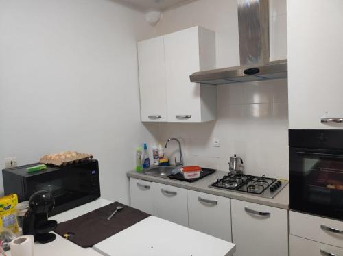 a kitchen with white cabinets and a stove top oven at casa mara dakar in Bargny