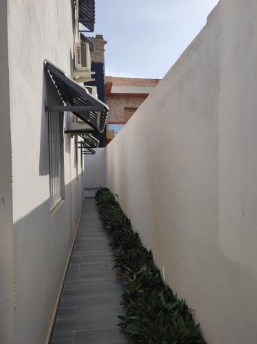 an alley between two buildings with an awnings and plants at casa mara dakar in Bargny