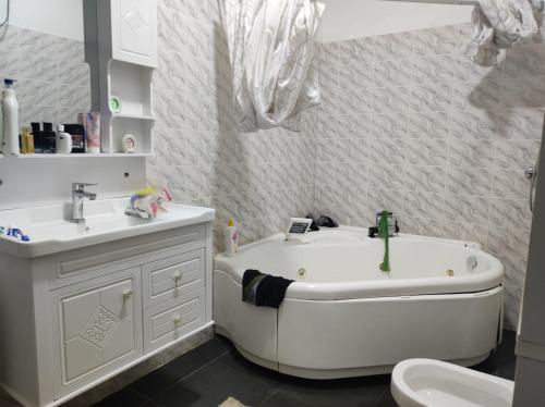 a bathroom with a tub and a sink and a toilet at casa mara dakar in Bargny