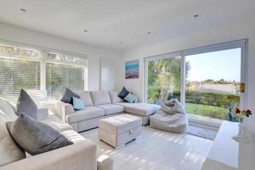 a living room with white furniture and a large window at Cilrhedyn in Saundersfoot