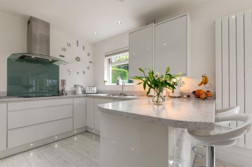 a kitchen with white cabinets and a marble counter top at Cilrhedyn in Saundersfoot