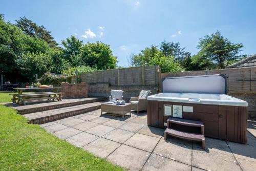 a backyard with a hot tub and a bench at Brambles in Croyde
