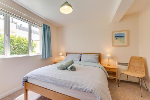 Un dormitorio con una cama y dos ventanas en Flat 11 Clifton Court, en Croyde