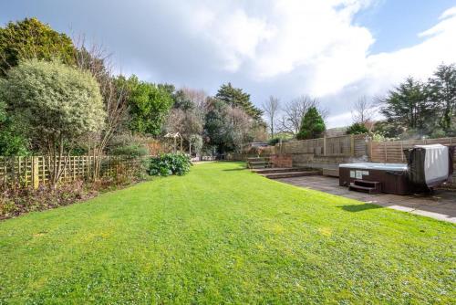 a grassy yard with a bench and a fence at Brambles in Croyde