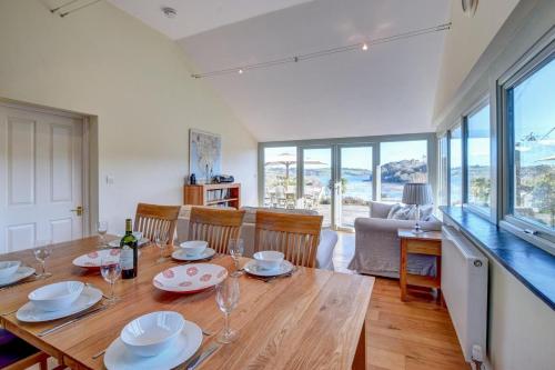 a dining room with a table and chairs and a kitchen at Lithuanica in Helford