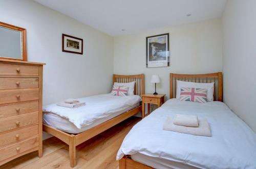 two twin beds in a bedroom with a dresser at Lithuanica in Helford