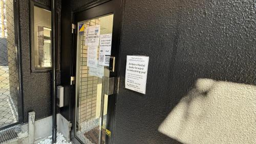 a door with signs on the side of a building at 心斎橋難波南Ambers hotel 3322 in Osaka