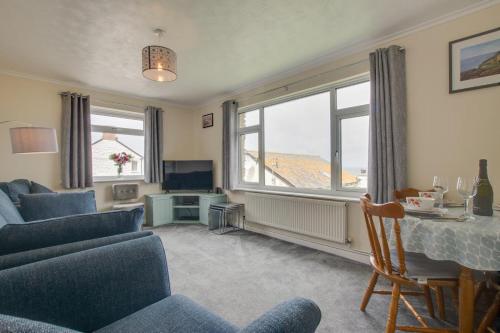a living room with a couch and a table and a window at Carn Base in Sennen