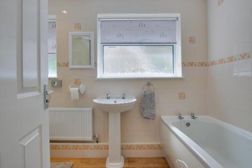 a bathroom with a sink and a tub and a window at Carn Base in Sennen