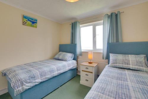 a bedroom with two beds and a window at Carn Base in Sennen