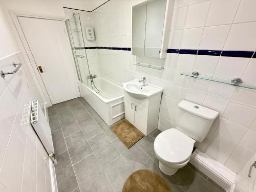 ロンドンにあるThe Finchley Grand Flat IIのトイレと洗面台を備えた白いバスルーム