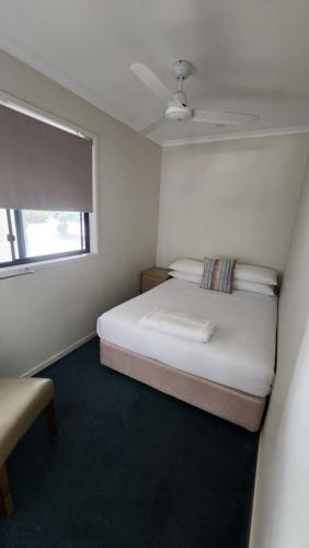 a small bedroom with a bed and a window at T's Resort & Motel in Port Macquarie
