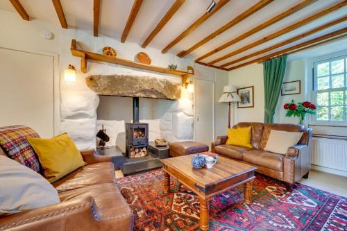 a living room with a couch and a fireplace at Ynys Pandy in Llanfihangel-y-pennant