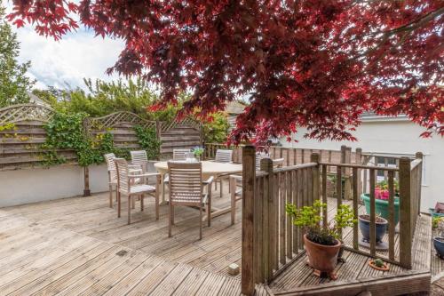 a wooden deck with a table and chairs at Windrush in Croyde