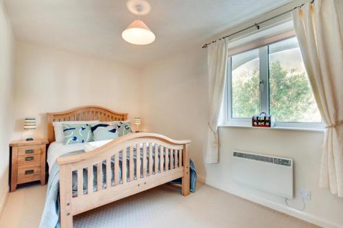 a bedroom with a crib and a window at Windrush in Croyde
