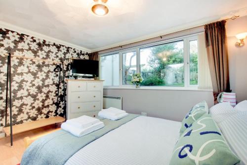 a bedroom with a bed and a window at Windrush in Croyde