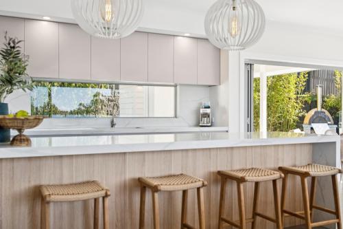 a kitchen with four stools at a counter at Gerald's Break Away - Style and luxury with Pool in Kororo Basin