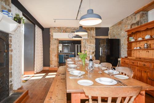a dining room with a long wooden table and chairs at Boslandew House in Paul