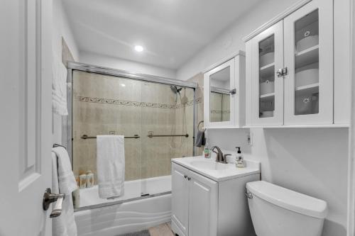 a bathroom with a shower and a toilet and a sink at Modern Cali Comfort- Spacious 3BR Home Near Disneyland & Beaches in Midway City