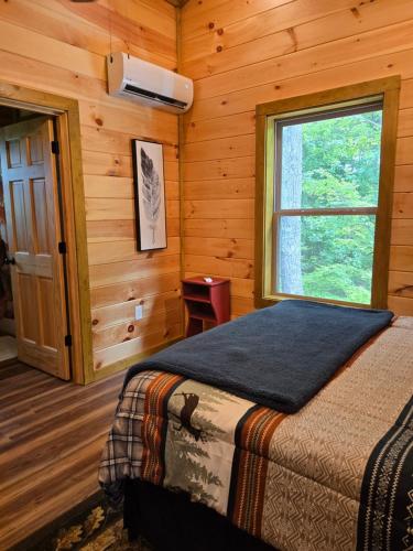 a bedroom with a bed and a window in a cabin at Smoky's View in Sevierville