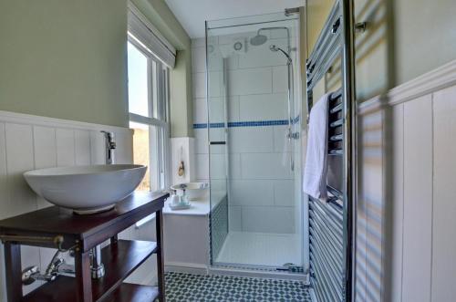 a bathroom with a sink and a shower at Hillside The Barn in Croyde