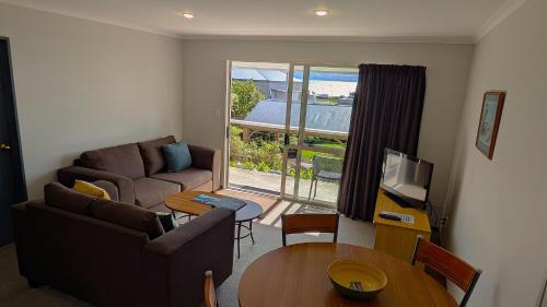 a living room with a couch and a table at The Peninsula Kaikoura in Kaikoura