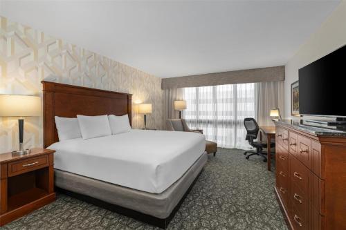 a hotel room with a bed and a television at Drury Plaza Hotel St Louis Creve Coeur in Creve Coeur